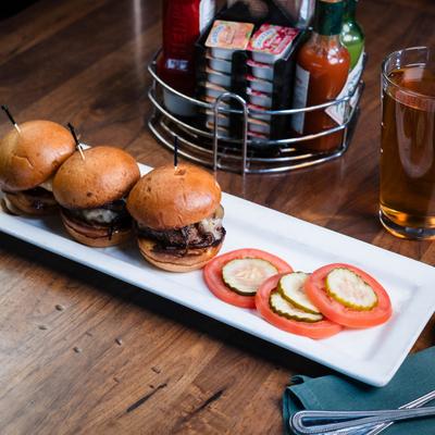 Three burgers with garnish.