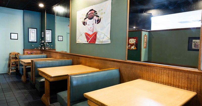 Interior view of a restaurant featuring teal booths and wooden tables