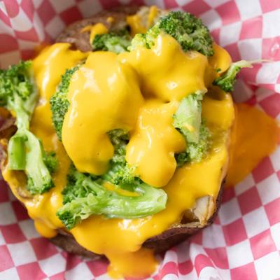 Baked potato topped with broccoli and cheese.