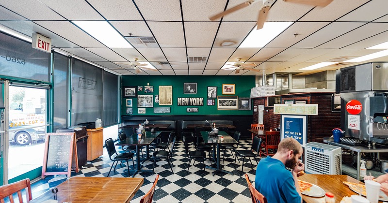 Interior, checkered floor, black tables and chairs