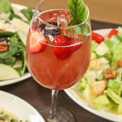 Specialty Mimosa served on a table with salads.