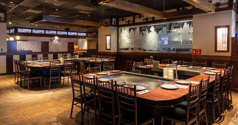 Interior seating area with teppanyaki grills and wooden tables and chairs