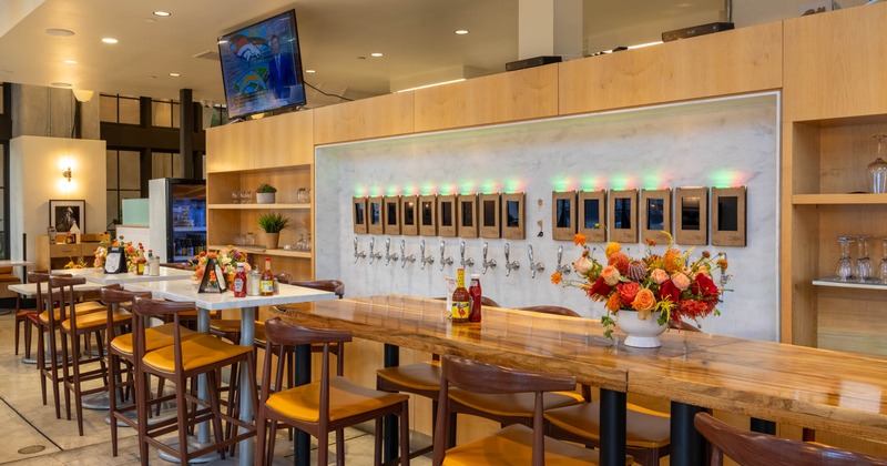Interior, bar area with beer taps, long wooden table, and floral decorations