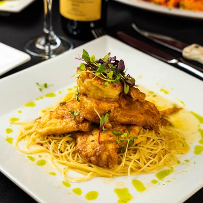 Breaded chicken and shrimp on a bed of pasta.