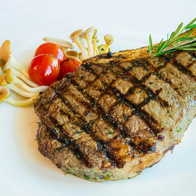 Grilled ribeye, served with mushrooms, rosemary, and cherry tomatoes.