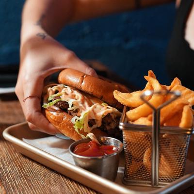 Double smash burger with a side of sidewinder fries and sauce dip.