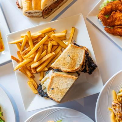 Steak sandwich served alongside fries on a white plate