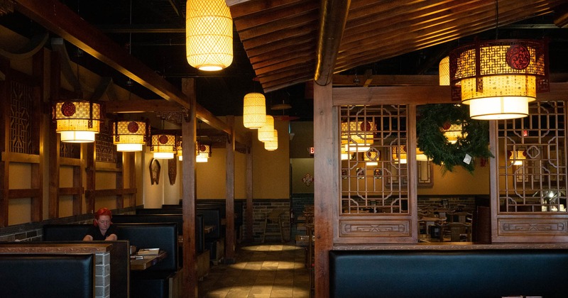 Interior, seating booths with tables, traditional Korean lanterns, decorative wood details