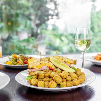 Multiple food plates displayed on a table with white wine