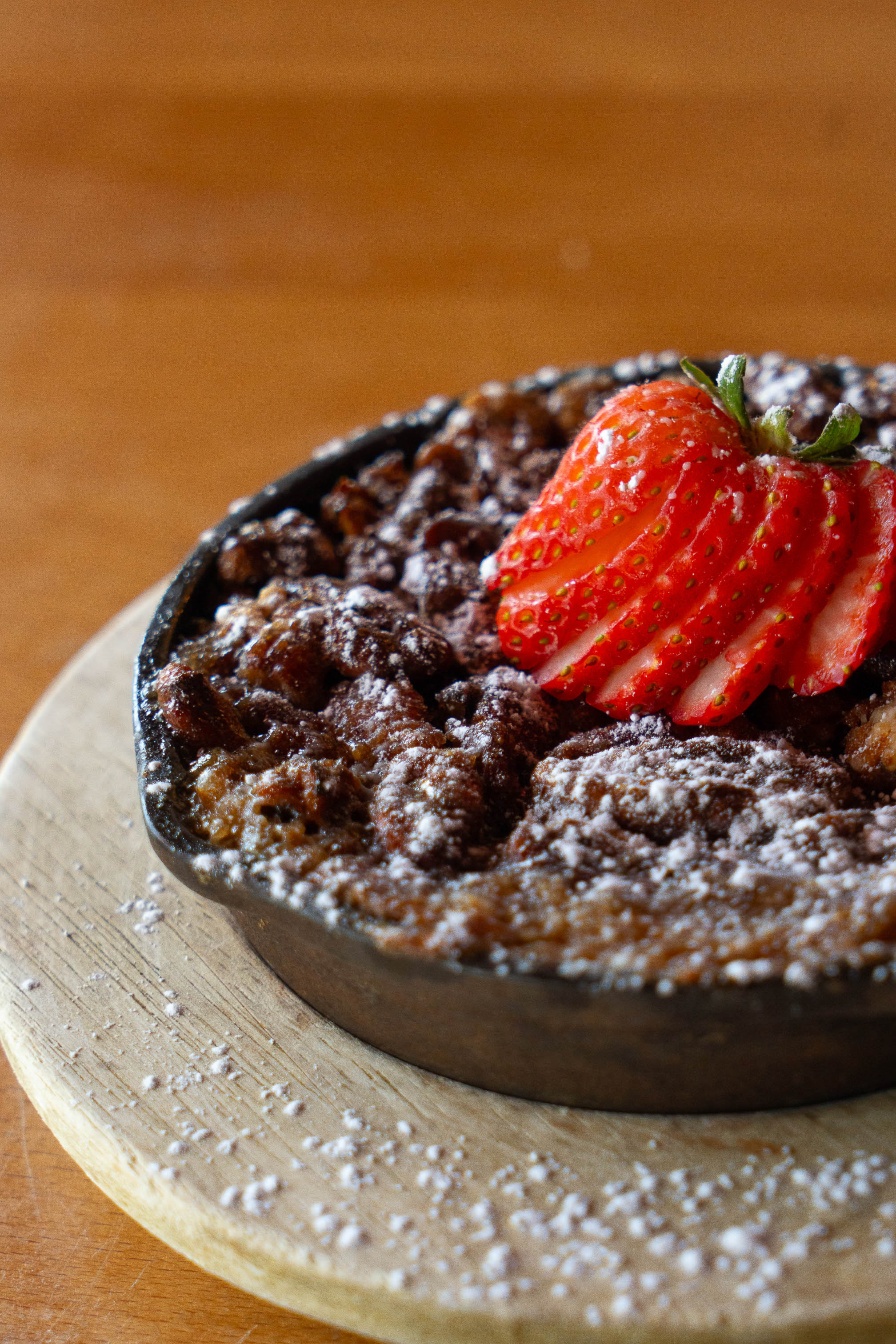 Pecan pie skillet with powdered sugar and strawberries