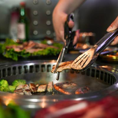 Flipping meat on the grill with tongs