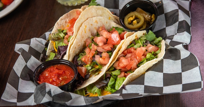 Tacos with with lettuce, cheddar cheese, tomato, and salsa
