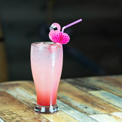 Pink cocktail garnished with a distinctive pink flamingo straw.