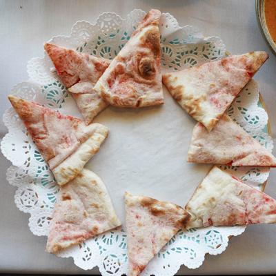 Naan brad slices served on a decorative doily.