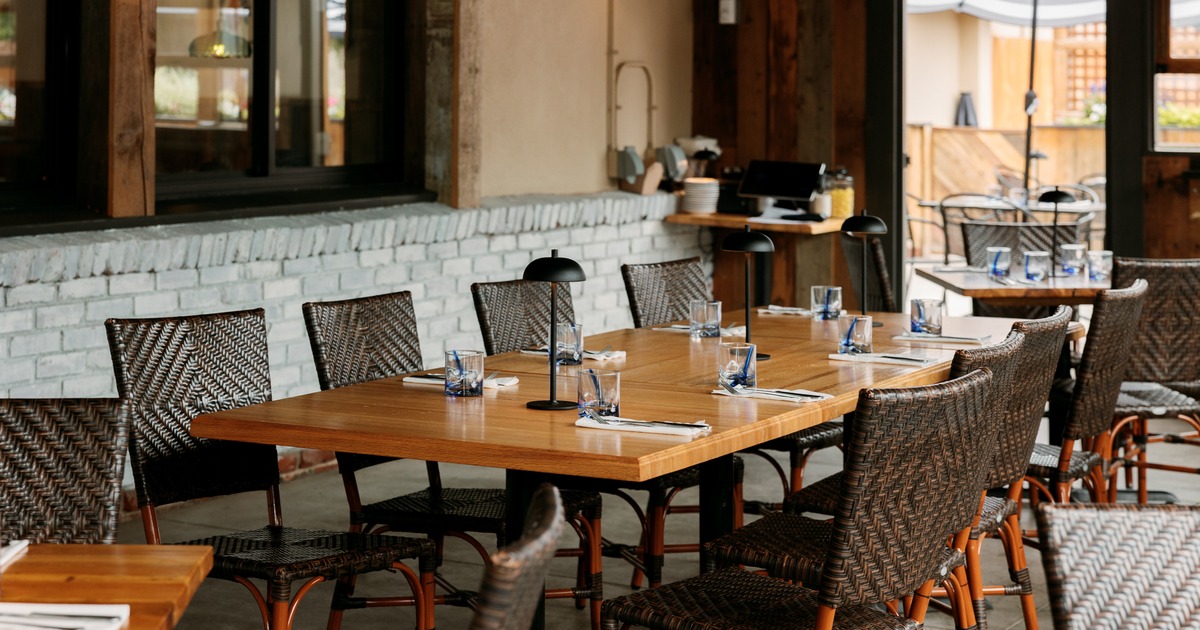 Restaurant interior with set wooden tables and wicker chairs
