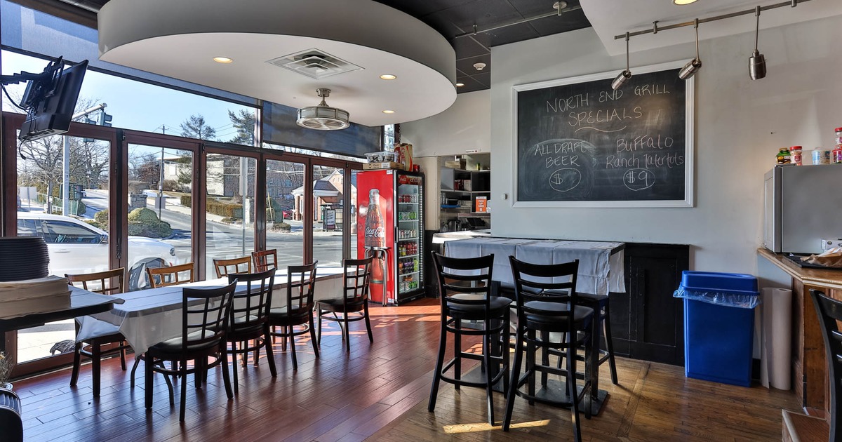 Interior, dining area, long table setup for eight people, large specials board, large shop window