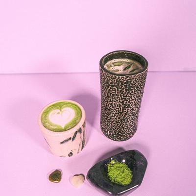 Hot matcha latte with latte art and iced matcha served with matcha powder.
