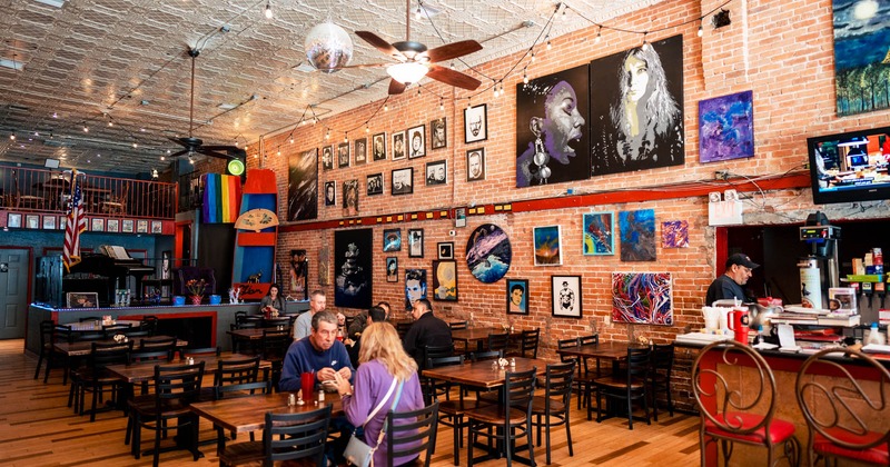 Interior, wide view, tables and chairs, guests sitting and chatting