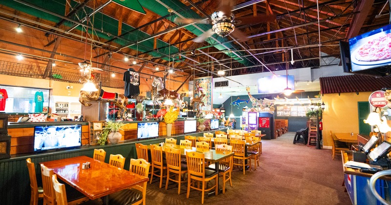 Interior of a lively restaurant with wooden beams, tables, chairs, decorative items