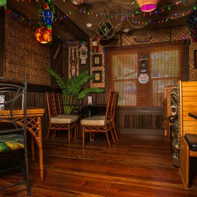 Restaurant interior, dining tables, chairs and booths, tiki decor.