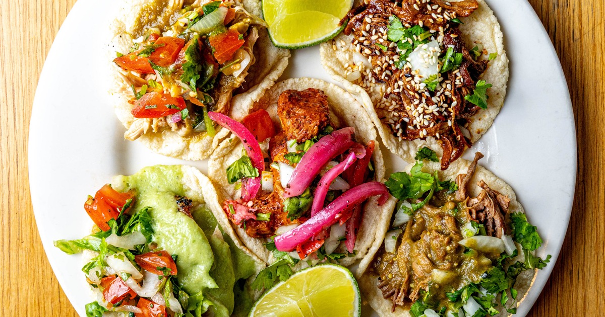 Assorted tacos with lime wedges