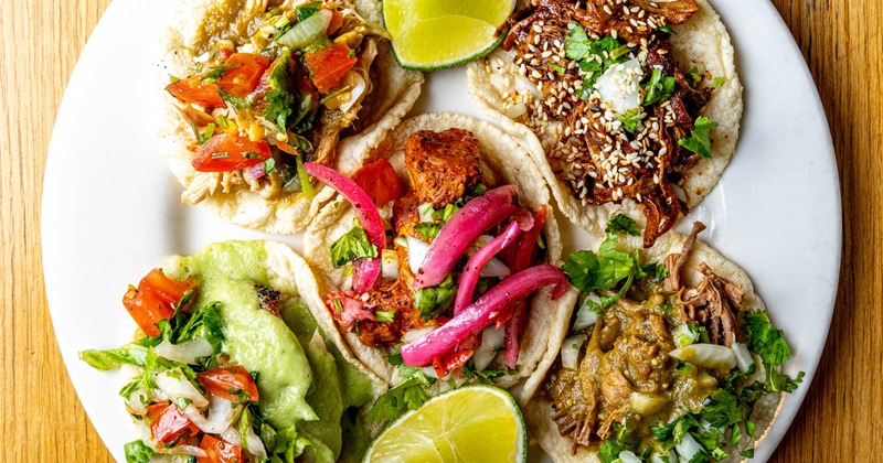 Assorted tacos with lime wedges