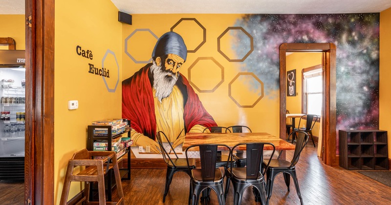 Interior, table for six, mural of Euclid on the wall, board games shelf, wooden baby stool