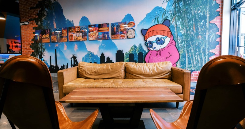 Interior, sofa with two chairs and coffee table, large mural on the wall