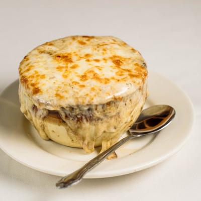 French onion soup topped with melted cheese, served with a spoon.