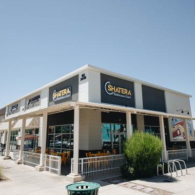 Restaurant building with white and dark-colored exterior with a covered outdoor patio.