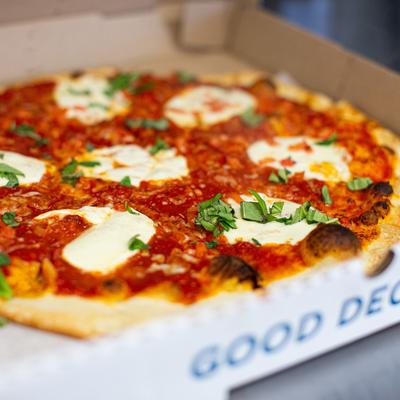 Margarita pizza in a takeaway box.