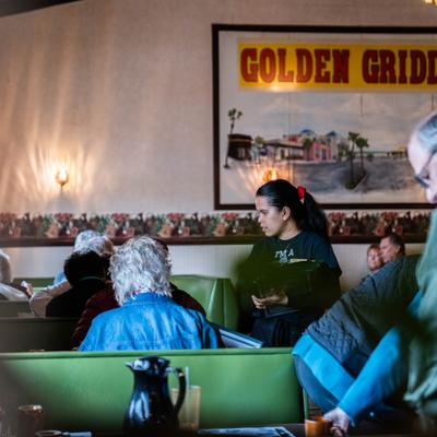Server taking an order from seated guests.