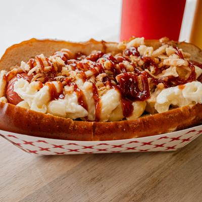 Backyard BBQ dawg topped with sauce and fried onion strips.