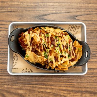 Nachos with cheese, bacon, and scallions.