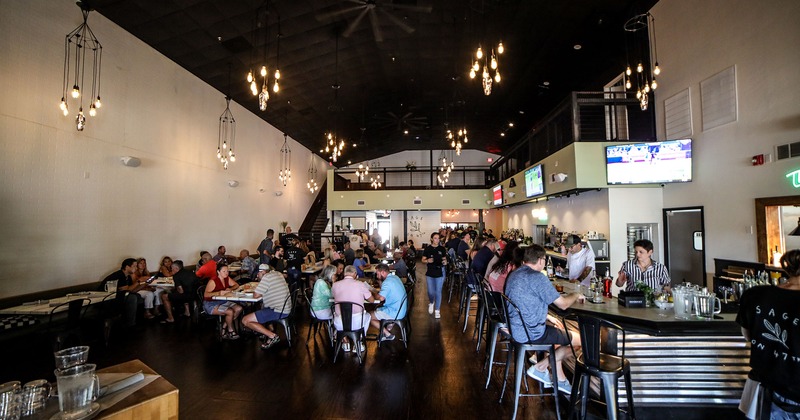 Restaurant interior, seating area and bar full of guests