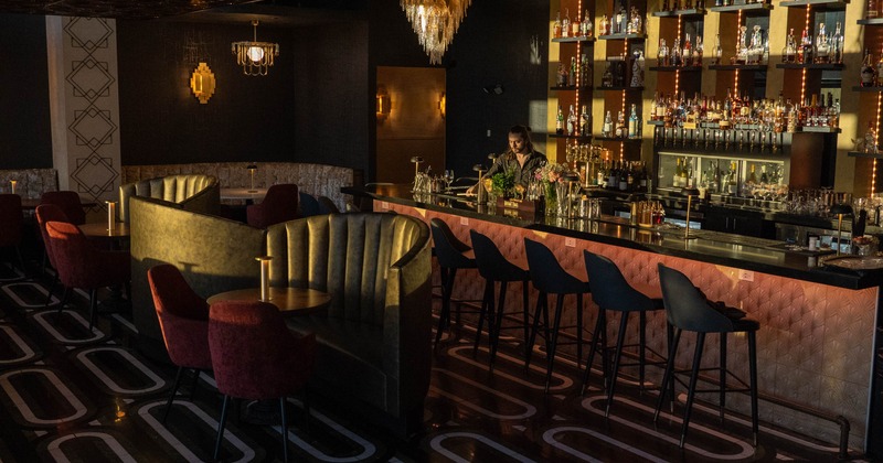 Interior, dining and bar area, large padded booth benches with tables and chairs