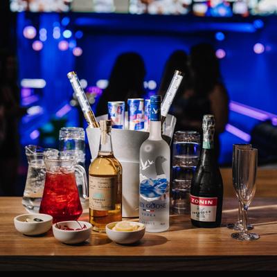 Bottle service, lined up bottles and glasses with Red Bull bucket.