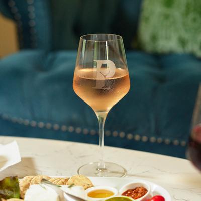 A glass of rosé wine and cheese and cracker plate, served.