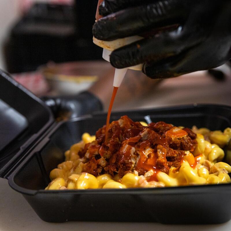 Pouring sauce on pasta with meat