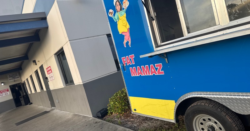 Blue food truck with a cartoon signage and a service window