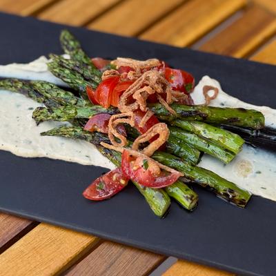 Grilled asparagus with crispy onions and tomatoes.