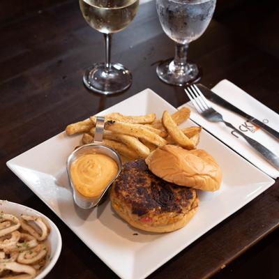 Crab cake burger with fries and dip.