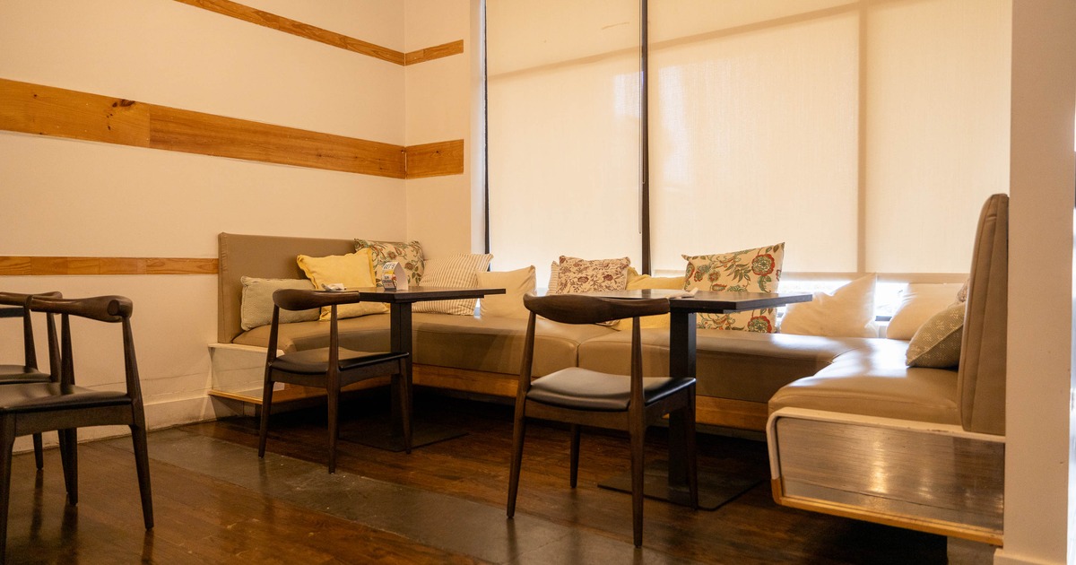 Cozy dining area with wooden tables, cushioned bench seating