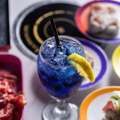 Ocean Water drink sits on a table surrounded by sushi plates.