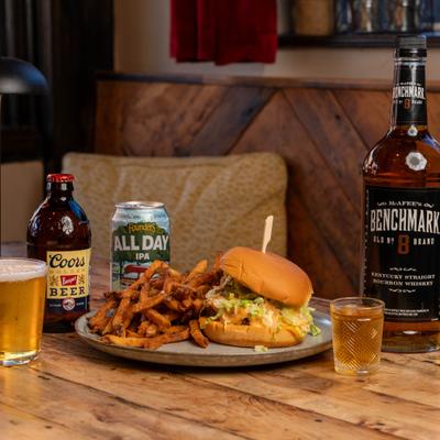 Cheeseburger with crispy fries paired with a selection of alcoholic beverages.