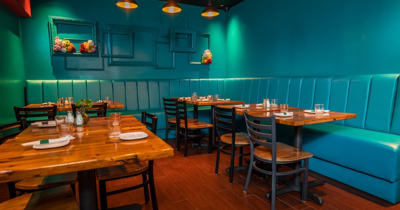 Interior, long corner banquette bench with wooden top tables and chairs