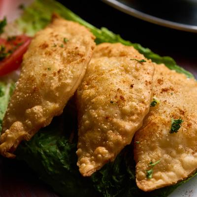 Fried cheese filled filo pastry on a bed of lettuce, closeup.