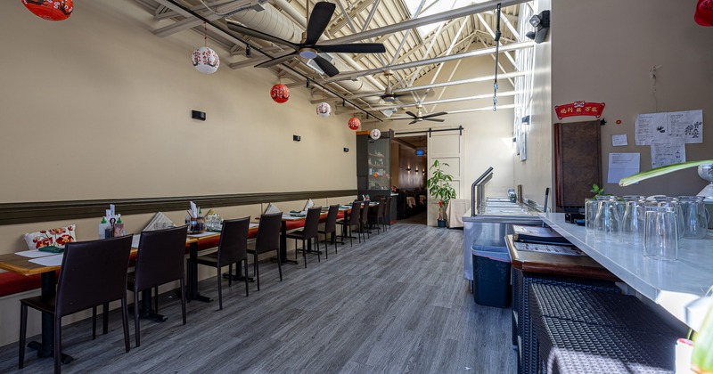 Spacious interior dining area with dining tables lined up along the wall