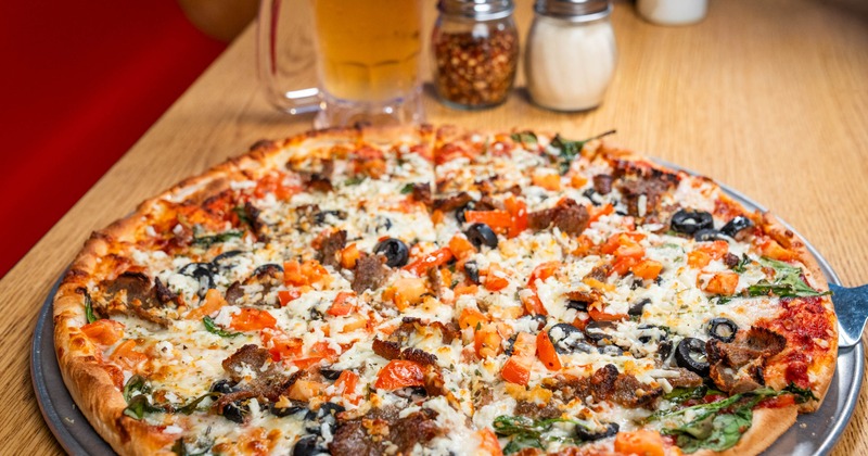 Zorba's Greek Favorite Pizza served on the table