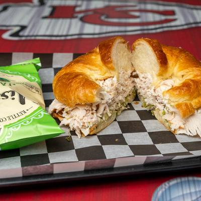 Turkey sandwich, with avocado, cream cheese, mayo, with a bag of jalapeno potato chips.